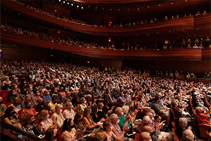 Wide view of an audience in Verizon Hall watching a performance.