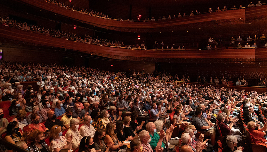 Wide view of an audience in Verizon Hall watching a performance.